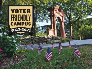 Flags planted in the grass in front of the Ramapo College Havemeyer Arch on a sunny spring day.