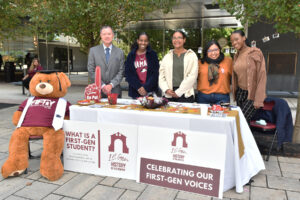 Ramapo College staff and students gather at a First-generation Student Center table on campus.