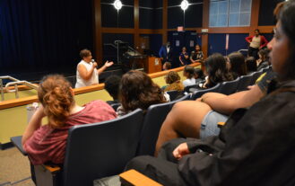 Assemblywoman Linda Carter addresses EOF students and staff at EOF orientation in an amphitheater-style classroom.
