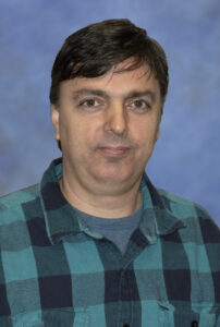 Professor Catalin Martin wearing a green and black plaid shirt.