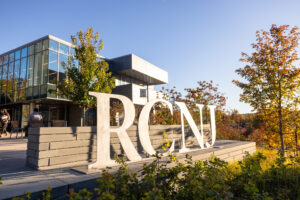 Big metal RCNJ letters sculpture in front of Learning Commons glass exterior