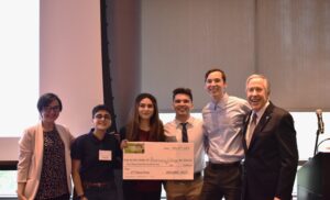 Prof. Nosrati stands with RCNJ students and a giant check for winning an award at the BAC@MC in 2023.