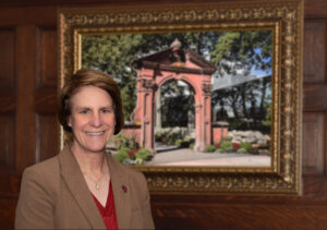 President Cindy Jebb stands in front of an oil painting of the Havemeyer Arch