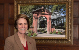 President Cindy Jebb stands in front of an oil painting of the Havemeyer Arch