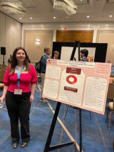 Melissa stands next to her research poster at the conference.