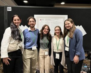Five Ramapo students stand in front of an academic poster on display.