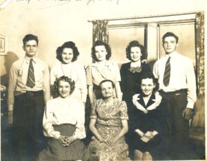 Black and white photo from early-to-mid 20th century of eight Gradl family members. Five stand in the back row and three sit in front of them.
