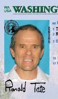 Washington State ID photo of Ronald Tate, cropped from the full ID. The image contains his signature. He is wearing a white collared shirt and the background is blue.