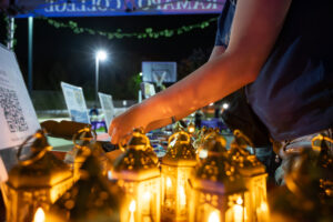 A group of lit lanterns are set on a table.