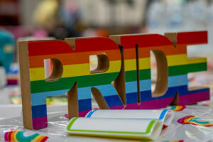 Rainbow letters on a table spell out PRIDE.