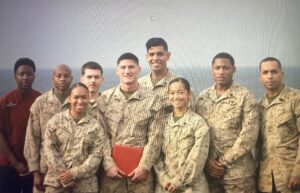 A group of U.S. Marines stands together shoulder to shoulder.