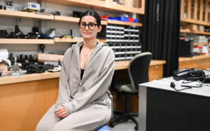 A young woman sits on a chair in a lab.