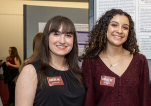 Two women stand togehter and smile.