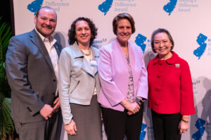 Chris Romano, Idana Goldberg, Cindy Jebb, and Angelica Berrie stand in a row in front of the Making A Difference Awards backdrop