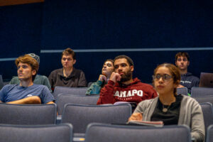 College students sit in seats and look forward.