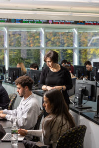 Students are seated at computers inside the Anisfield School of Business trading center
