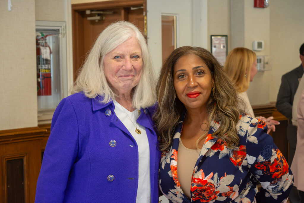 RCNJ Assistant Dean & Professor of Nursing Kathleen Burke stands with Karine Austin, DNP smiling at the camera at the September 17, 2026 Pipeline to Practice signing event. Kathleen is wearing a white shirt and purple blazer. Karine is wearing a taupe shirt and a floral blazer.