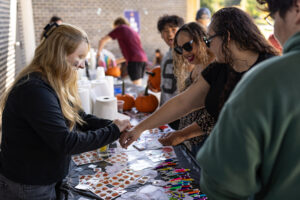 A crowd lines a table to get temporay tatoos.