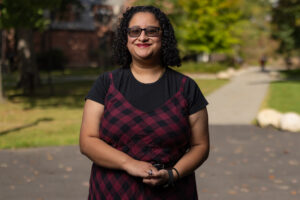 A college student stands outside.