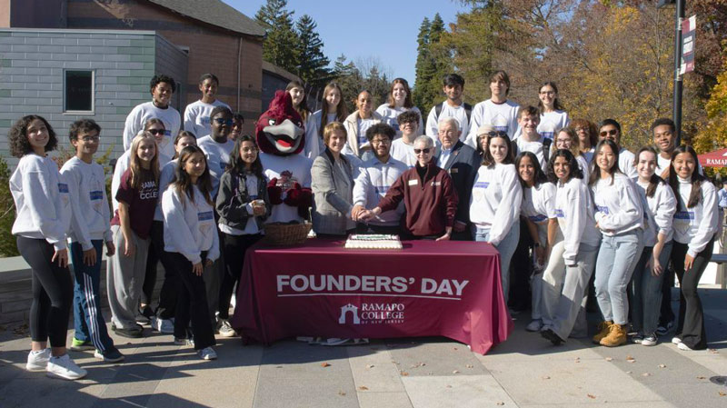 Large group of faculty, staff and students around a table for Founders Day at Ramapo College