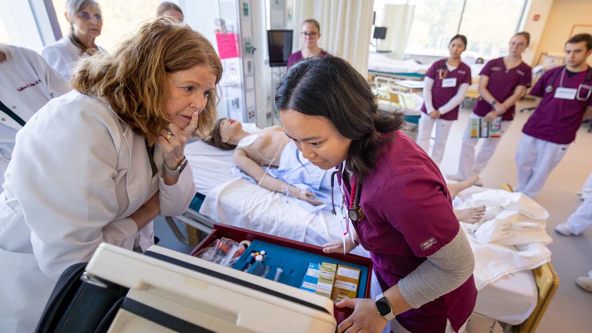 College nursing students observing a monitor in the simulation lab