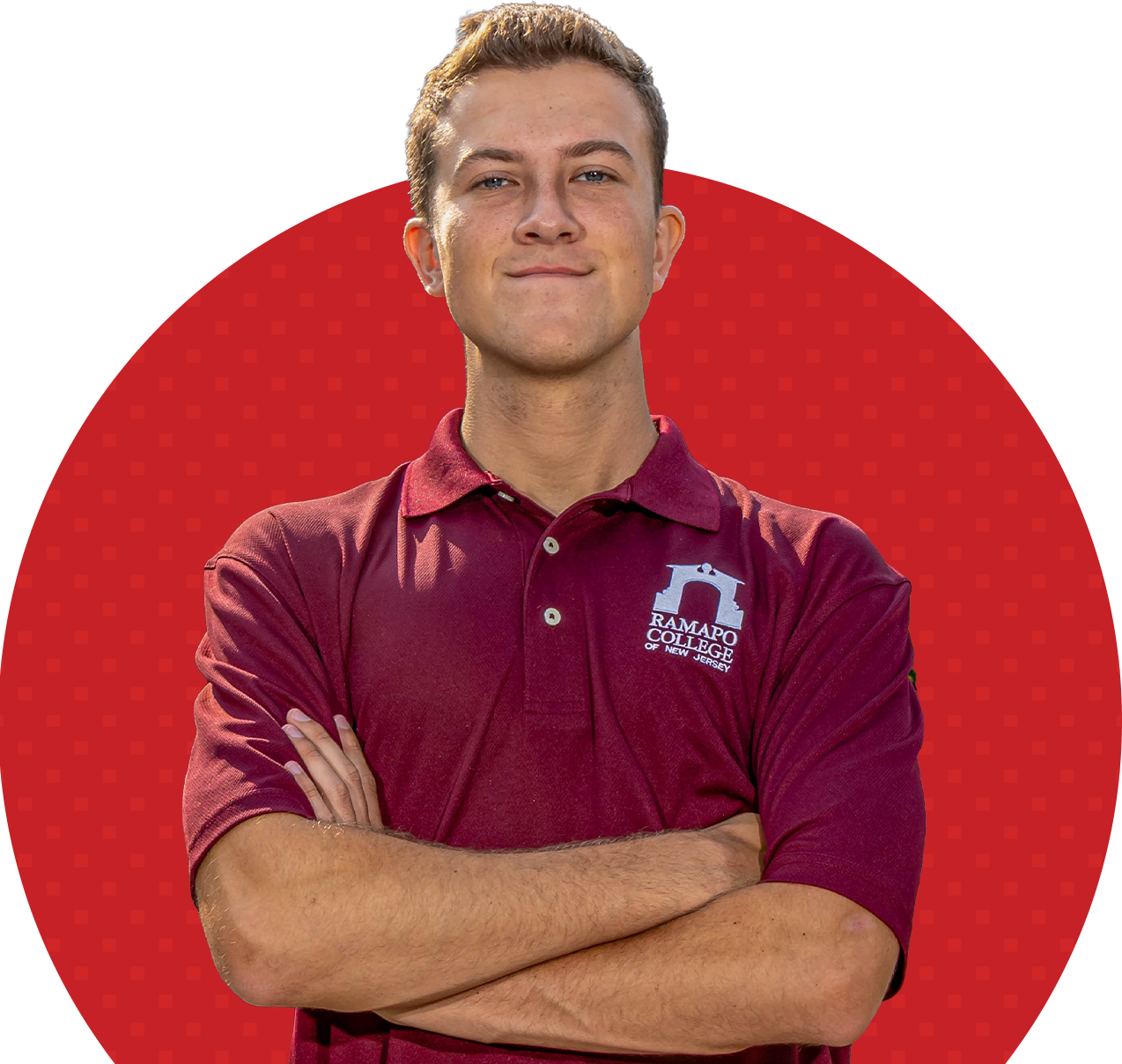 Confident young man in a maroon Ramapo College polo stands with arms crossed before a red dotted circle, conveying pride.