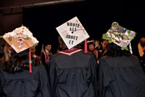 Students displaying their decorated graduation caps.