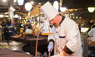 Chef cooking at Ramapo College wearing a white chef's hat