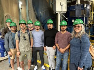 Students standing in front of equipment inside the Great Falls Hydroelectric Station