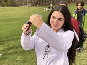 Student watching the solar eclipse through her phone.