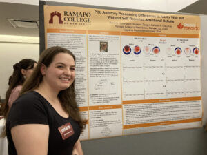 Student posing in front of their research poster.