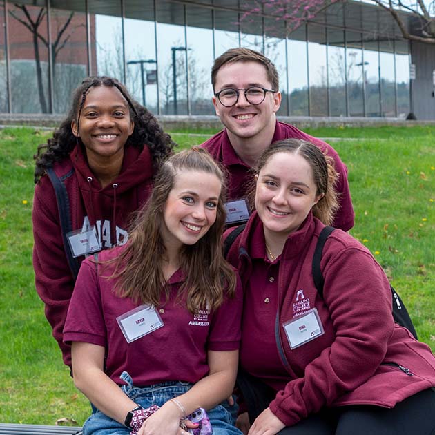 a group of four students wearing Ramapo College t-shirts